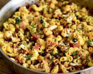 Pasta with cauliflower, currants and pine nuts in a silver pan